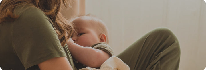 Mom holding her newborn baby close at home