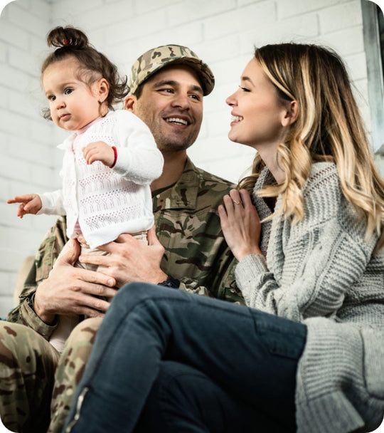 Military dad in uniform holding his baby next to mom